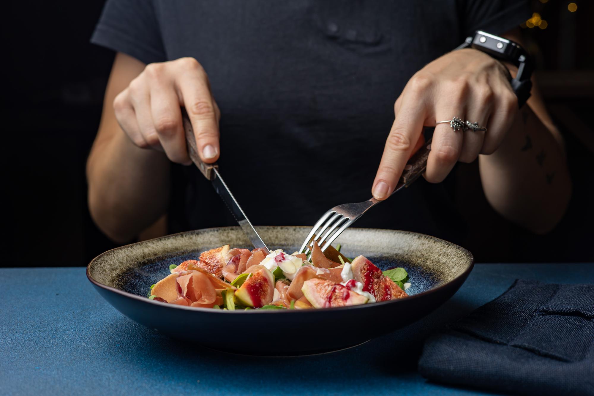 Chef preparing a plated gourmet dish with precise hands
